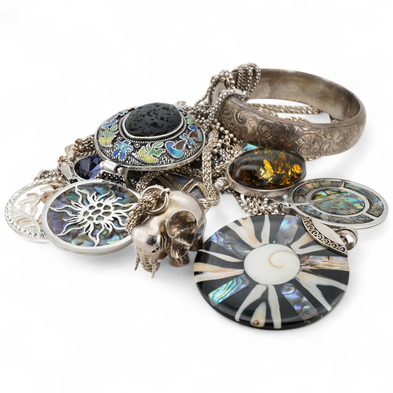 A collection of silver and costume jewellery, comprising: a pendant designed as an elephant; an enamel and porous black stone pendant; five shell medallion pendants; two paste pendants; and a treated amber pendant; all w